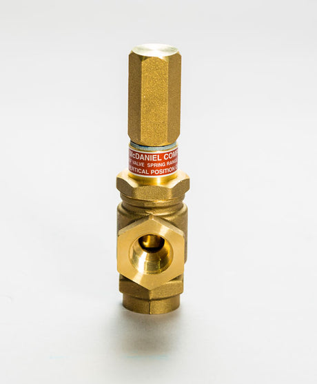 The Watson McDaniel Relief Valve R 10691 Series: 3/4 features a brass hexagonal top, cylindrical body with a label detailing brand and specs, and a threaded bottom with central hexagonal nut for precise control.